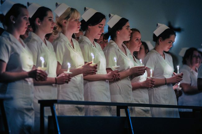 Nursing majors holding candles during nursing dedication