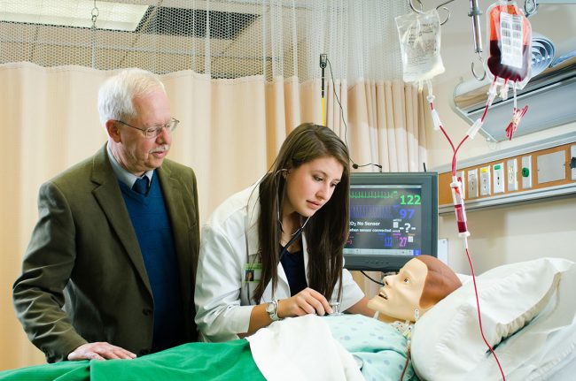 Professor Antinone assisting a nursing student with a nursing dummy