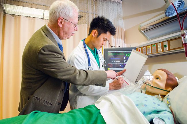 Teacher and student over nursing dummy